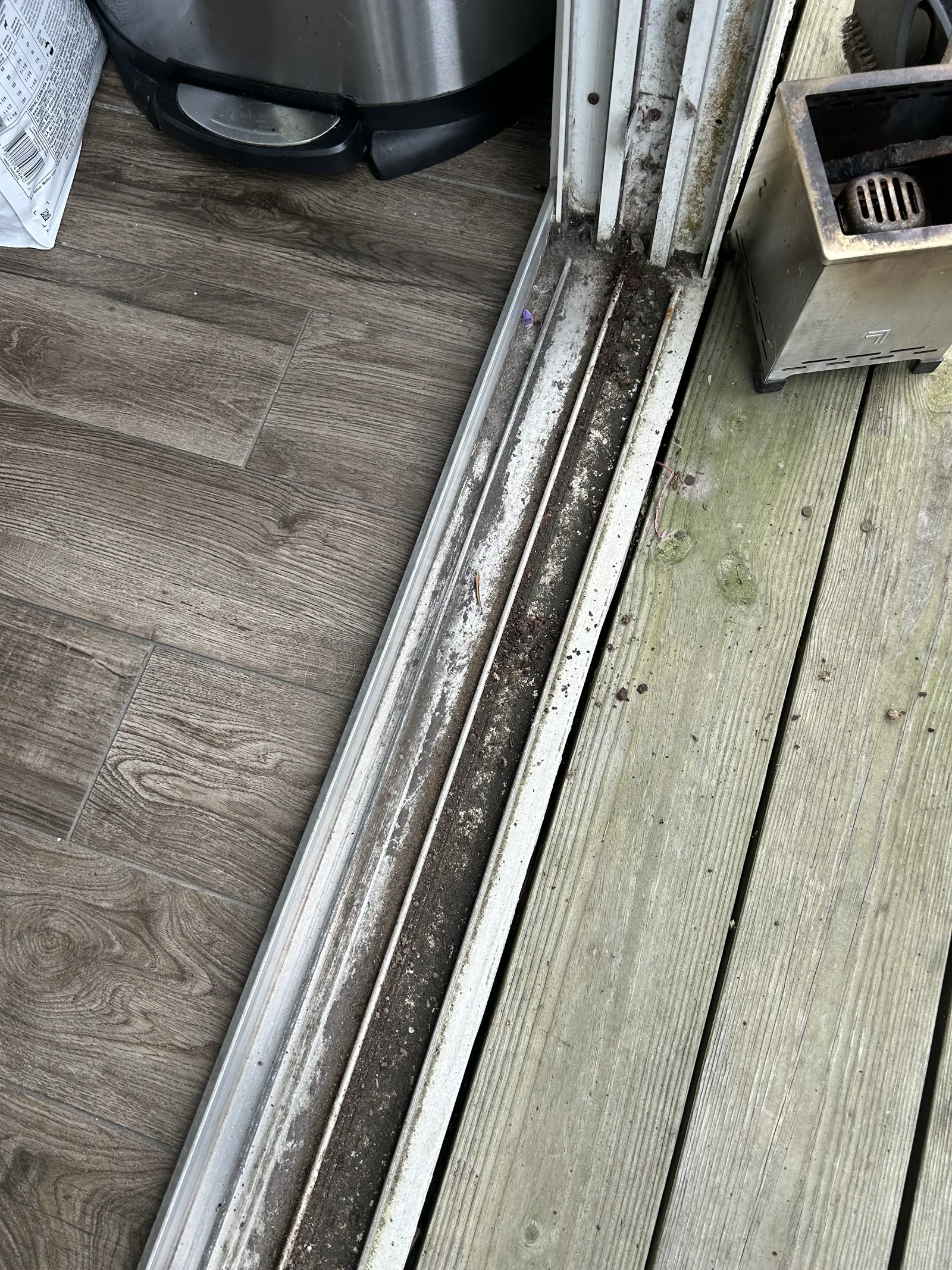 Dirty sliding door track packed with debris